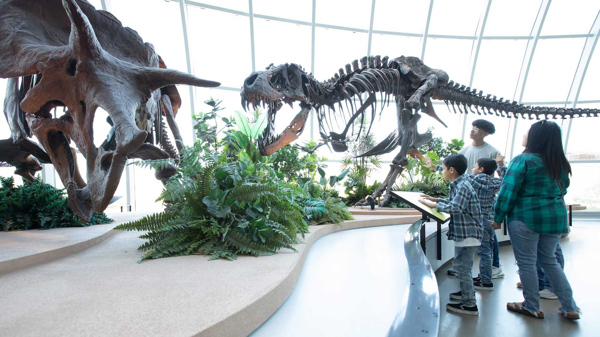 Family looking at dinosaur skeletons in Dinosaur Hall at Discovery Park of America in Union City Tennessee